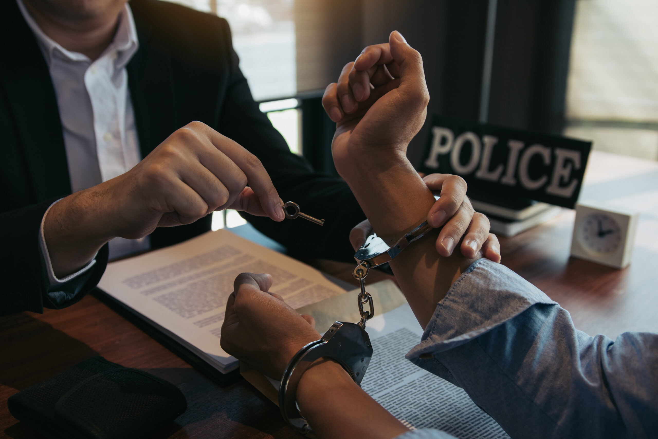 man unlocking handcuffs on another man
