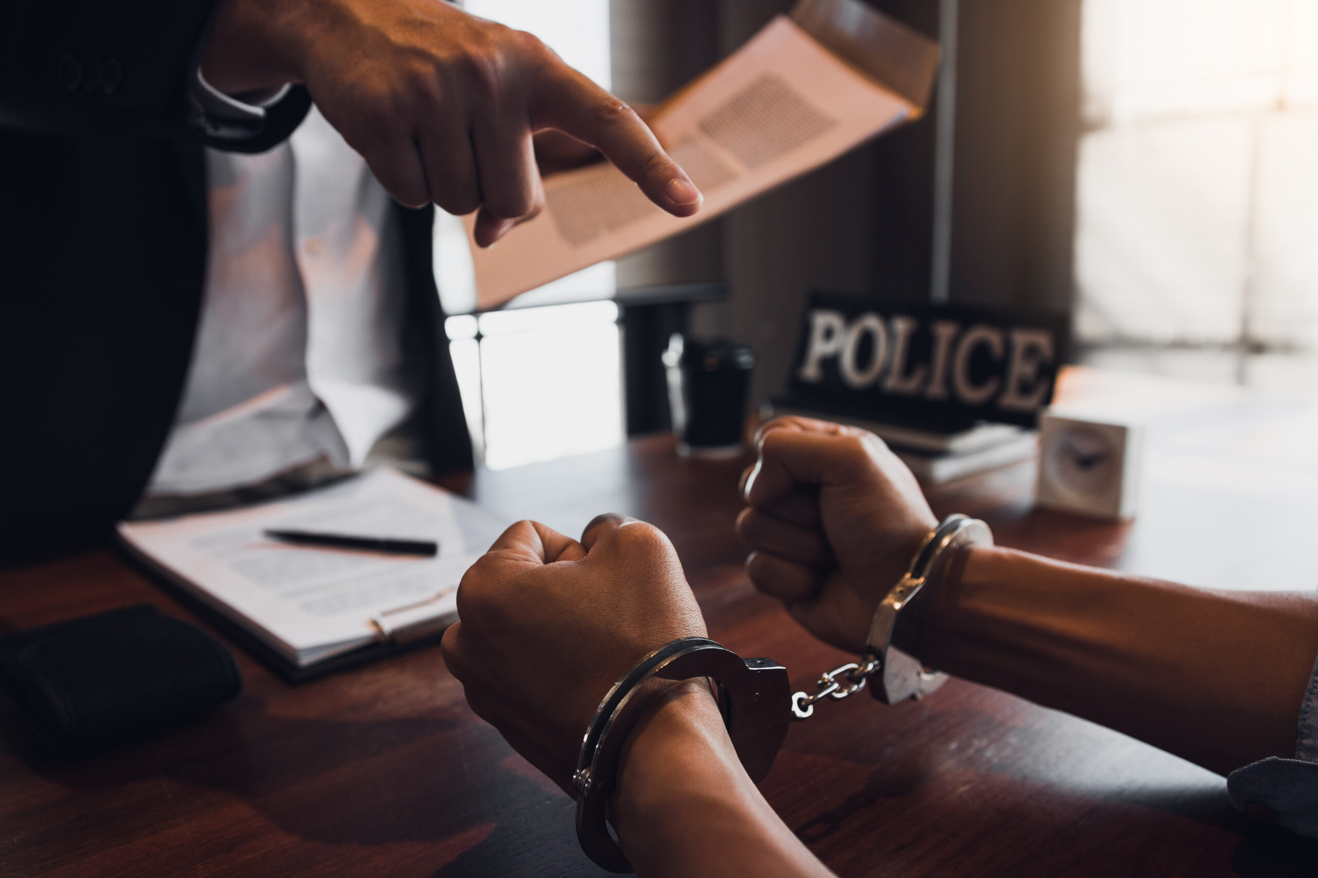 policeman points at an arrested person